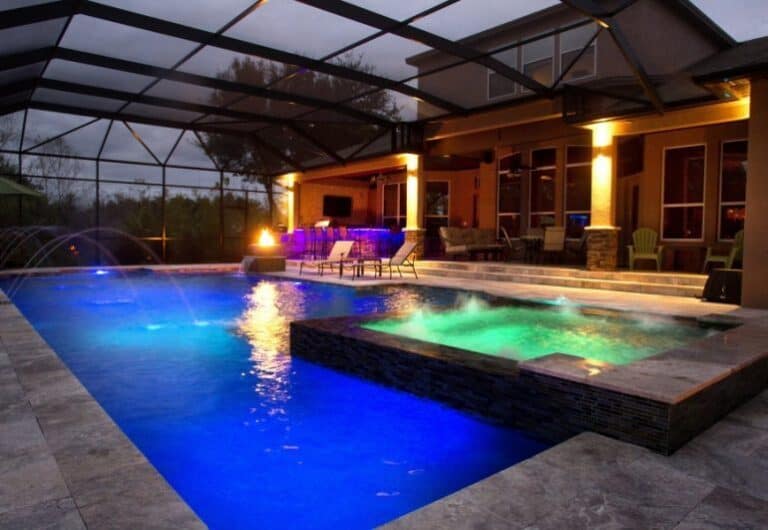 Luxury backyard pool with colorful lighting and screened enclosure in Tampa.