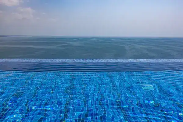 Infinity edge pool overlooking the ocean in Florida with clear blue water.